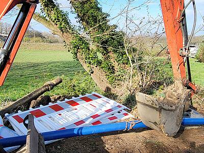 Das PE-Rohr ist an der Baggerschaufel befestigt.