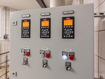 Steuerung der Pumpen: Ein Panel mit drei Kontrolldisplays und Schaltern.
