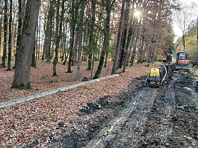 Bagger und Schaffußwalze an Baustelle