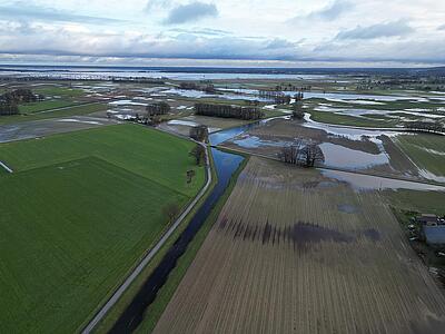 Die Norddeutsche Tiefebene – eine Wasserlandschaft.  Das Luftbild zeigt das Gewässersystem der Oberen Hunte von Hunteburg bis zum Dümmer.  Im Vordergrund die Elze bis zur Mündung in die Hunte. Deutlich sieht man die Retentionsräume, die durch Renaturierungsmaßnahmen des Unterhaltungsverbandes Nr. 70 „Obere Hunte“ (UHV 70) realisiert wurden.  Im weiteren Verlauf die Hunte mit Schöpfwerk. Der Schäferhof in Stemshorn markiert den Eingang zum Ochsenmoor – dieser Tage eine einzige große Wasserfläche. Links im Hintergrund der Dümmer.
