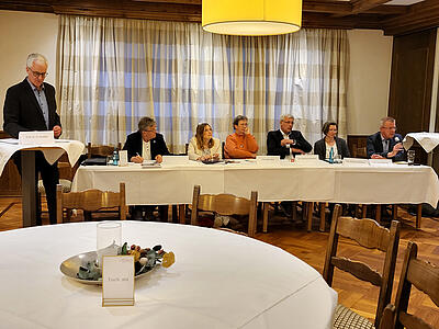 Moderator Prof. Olaf Hemker, das Podium mit (v.l.) Heinfried Helms, Silke Depker, Elke Eilers Michael Kipsieker, Audrey Averdiek und Uwe Bühning an einem Tisch im Saal von Högers Hotel