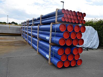 Blaue PE-Rohre liegen auf einem Stapel.