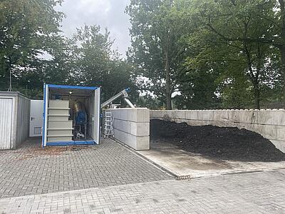 Die Presse ist in einem Container verbaut, der getrocknete Klärschlamm wird aus der Presse in ein Magazin befördert.