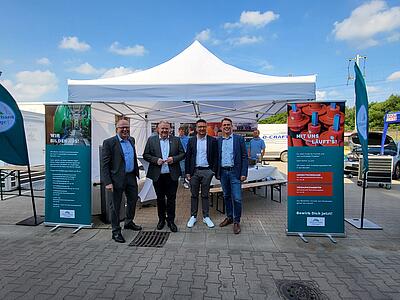 Gruppenbild mit Vertretern der Wittlager Gemeinde und der Maßarbeit vor dem Stand des Wasserverbandes Wittlage.